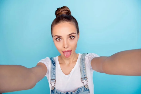 Self photo of charming cute attractive playful girlfriend showing you her tongue while isolated with blue background — Stock Photo, Image