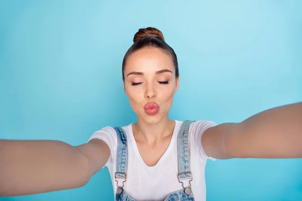 Αυτοπροσωπογραφία του χαριτωμένο γοητευτικό φλερτ δελεαστικό κορίτσι φιλιά σας μέσω κάμερας, ενώ απομονώνονται με μπλε φόντο — Φωτογραφία Αρχείου