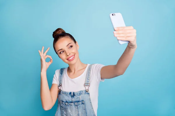 Foto van casual schattig mooi meisje dragen jeans denim beïnvloeden van mensen via sociale media op de telefoon, terwijl geïsoleerd met blauwe achtergrond — Stockfoto