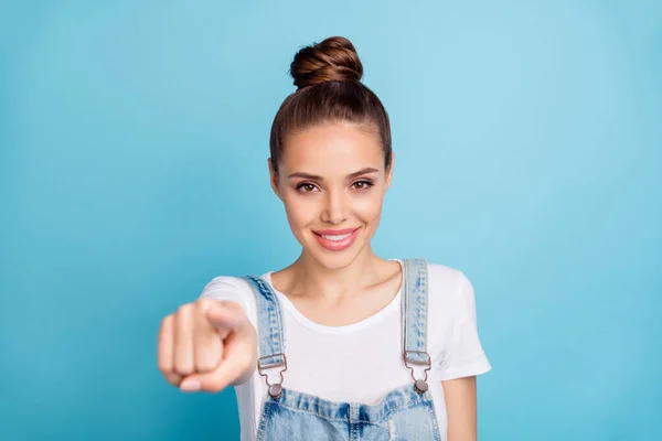 Porträtt av positiv flicka visar hennes pekfinger bär vit t-shirt jeans isolerad över blå bakgrund — Stockfoto