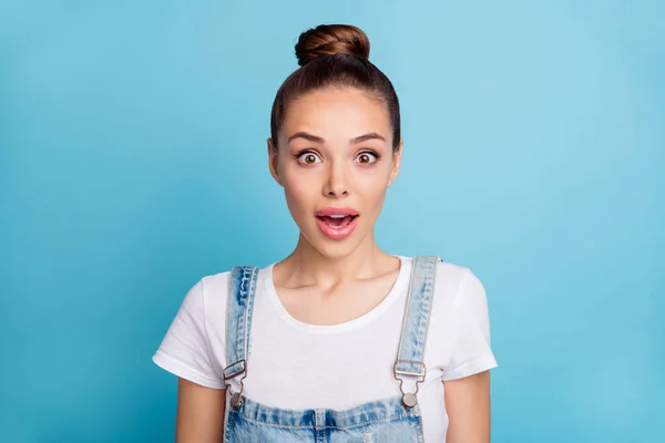 Close-up foto van verbaasd persoon op zoek met geopende mond het dragen van witte t-shirt denim jeans overalls geïsoleerd over blauwe achtergrond — Stockfoto