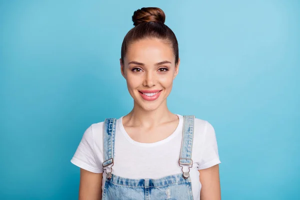Close-up foto van charmante dame op zoek met een tand glimlach het dragen van witte t-shirt denim jeans overalls geïsoleerd over blauwe achtergrond — Stockfoto