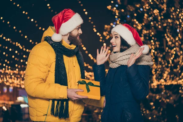 Foto de duas pessoas casal marido cara dando animado surpreendido mulher senhora seu x-mas giftbox noel tradição ano novo usar casacos santa bonés scarfs newyear parque ao ar livre — Fotografia de Stock