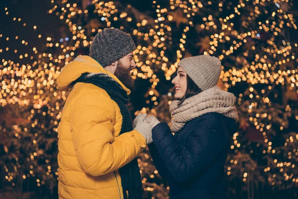 Foto de duas pessoas casal cara senhora sonhador segurando as mãos iluminado parque newyear x-mas noite frio tempo stand oposto desgaste casacos de inverno scarfs chapéus luvas ao ar livre — Fotografia de Stock
