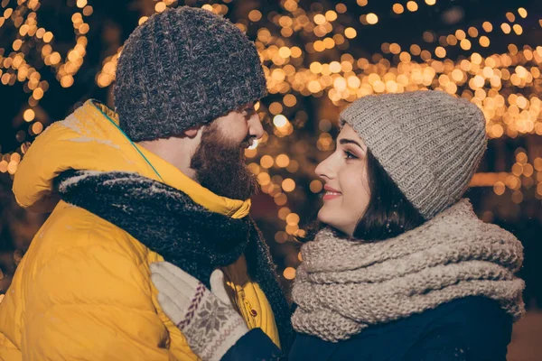 Profil fotografie dvou lidí pár chlap dáma ve městě osvětlené půlnoční park novoroční x-mas večer stojí naproti vypadající oči nosí zimní bundy šály klobouky venku — Stock fotografie