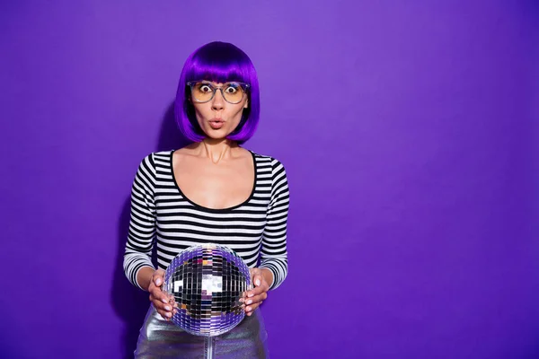 Retrato de senhora impressionada com óculos óculos segurando bola espelho isolado sobre fundo violeta roxo — Fotografia de Stock