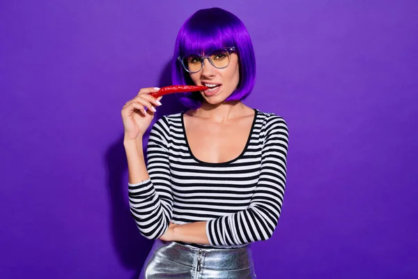 Pretty lady hold red chili pepper in mouth fearless person likes spicy food wear specs striped pullover isolated purple background