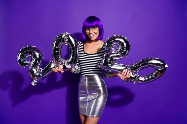 Foto von erstaunlichen Dame halten Hände Ballons feiern neue 2020 Jahr tragen Spezifikationen Rock gestreiften Pullover isoliert lila Hintergrund — Stockfoto