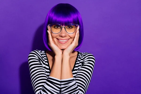 Foto de las manos de la señora agradable tocar mejillas llenas de alegría usar peluca a rayas pulóver aislado fondo púrpura —  Fotos de Stock