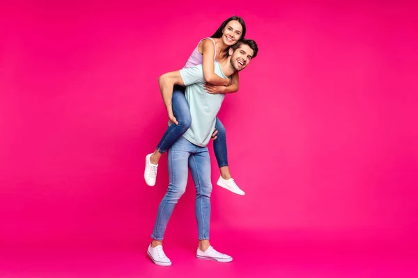 Pełna długość zdjęcie zabawny facet i pani gospodarstwa piggyback spędzać najlepszy wolny czas nosić casual ubrania izolowane żywy różowy kolor tło — Zdjęcie stockowe