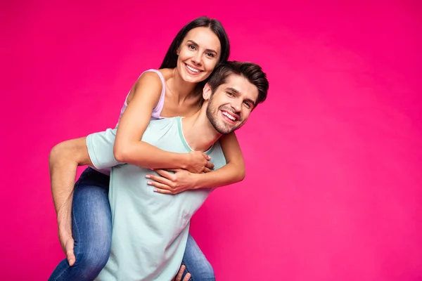 面白い男と女の写真保持ピギーバック支出ベストフリー時間を着用カジュアル服絶縁鮮やかなピンク色の背景 — ストック写真