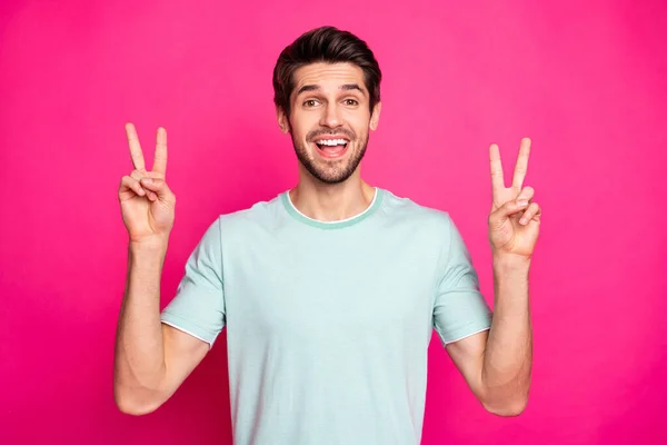 Φωτογραφία από αστείο macho τύπος δείχνει σύμβολο v-σημάδι λέγοντας γεια στους καλύτερους φίλους φορούν casual t-shirt απομονωμένο ζωντανό ροζ φόντο χρώμα — Φωτογραφία Αρχείου