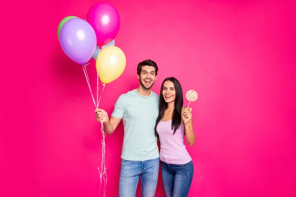 Foto von lustigen Kerl und Dame mit Luftballons in den Händen kam zu Eltern Geburtstagsparty mit Zuckerbonbon tragen lässiges Outfit isoliert rosa Farbe Hintergrund — Stockfoto