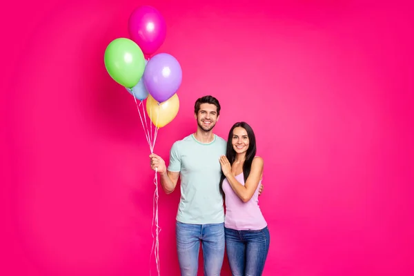 Φωτογραφία του γοητευτικού άντρα και η κυρία ζευγάρι κρατώντας μπαλόνια αέρα στα χέρια ήρθε στους γονείς πάρτι γενεθλίων φορούν casual στολή απομονωμένο ροζ χρώμα φόντο — Φωτογραφία Αρχείου