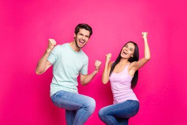 Photo of crazy couple guy and lady raising fists up celebrate summer vacation coming wear casual clothes isolated bright pink color background clipart