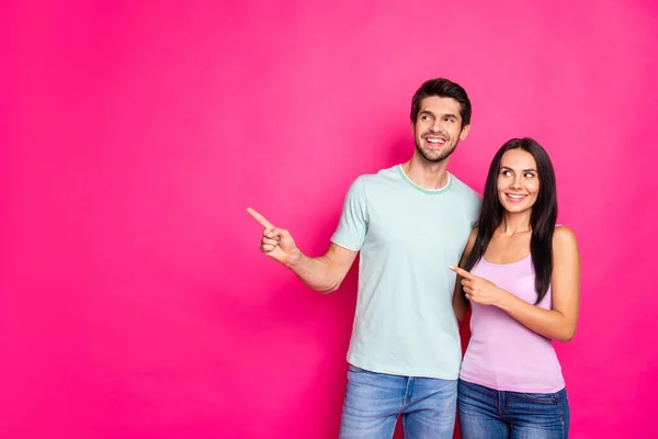 Photo of amazing couple guy and lady indicating fingers to empty space advising black friday shopping wear casual clothes isolated vivid pink color background — Stock Photo, Image