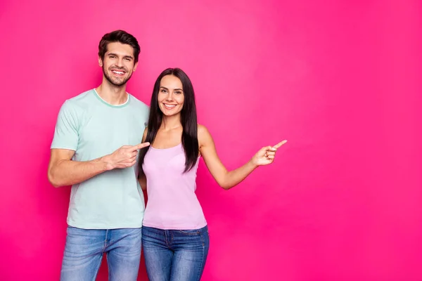 Foto de casal engraçado cara e senhora indicando dedos para espaço vazio aconselhando preto sexta-feira compras desgaste casual roupas isoladas vívido cor-de-rosa fundo — Fotografia de Stock