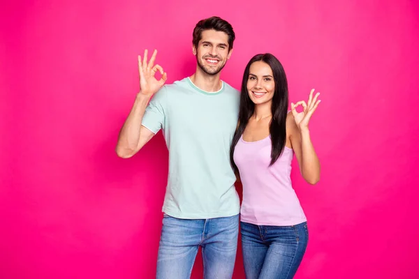 Foto de casal engraçado cara e senhora levantando as mãos mostrando símbolos okey aprovando respostas positivas usar roupas casuais isolado cor rosa brilhante fundo — Fotografia de Stock