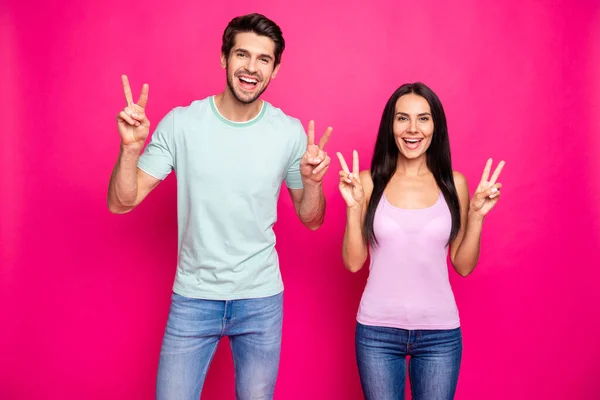 Γεια σας, αγαπητοί φίλοι. Φωτογραφία του αστείου άντρα ζευγάρι και κυρία σηκώνοντας τα χέρια δείχνει τα σύμβολα v-σημάδι φορούν casual ρούχα απομονωμένο φωτεινό ροζ χρώμα φόντο — Φωτογραφία Αρχείου