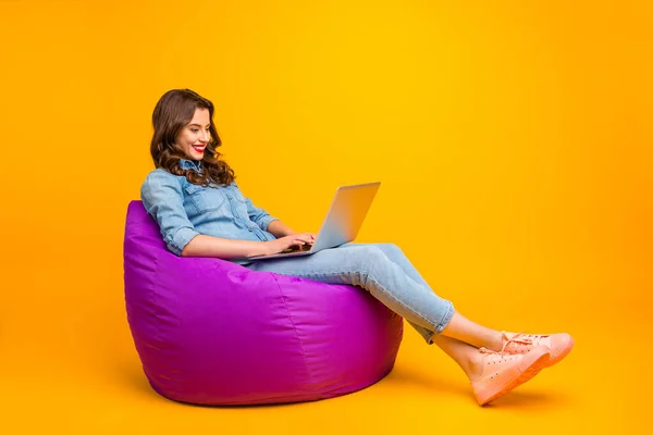 Longitud completa tamaño del cuerpo convertido foto de alegre positivo lindo bloguero atractivo agradable navegar a través de su ordenador portátil en busca de nueva información aislada sobre el fondo de color vibrante amarillo —  Fotos de Stock