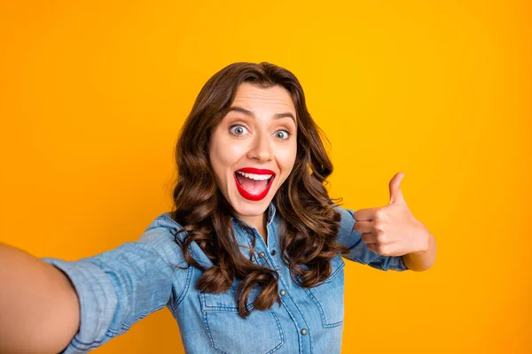 Photo of cheerful charming brunette cute nice positive sweet girl taking selfie calling video expressing shock and stun showing you thumb up isolated over vivid yellow color background — Stock Photo, Image