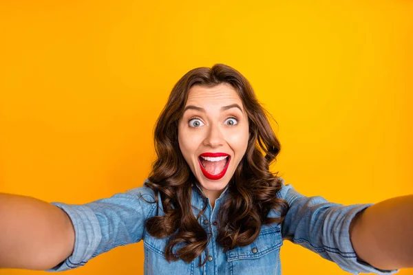 Foto de encaracolado ondulado na moda alegre animado morena peludo menina se alegraram com ser capaz de atirar fotos e vídeos tirando selfie mostrando suas emoções positivas isoladas sobre fundo de cor vívida — Fotografia de Stock