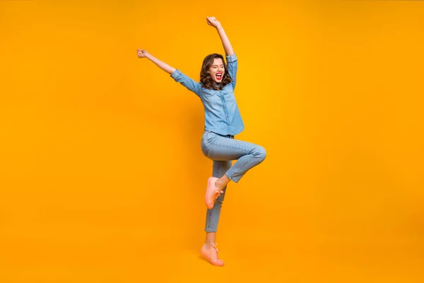 Ganzkörpergröße Foto von fröhlichen positiven netten charmanten hübschen Mädchen freut sich über ihren Abschluss High School hebt die Hände und schreit isoliert über gelben lebendigen Farbhintergrund — Stockfoto