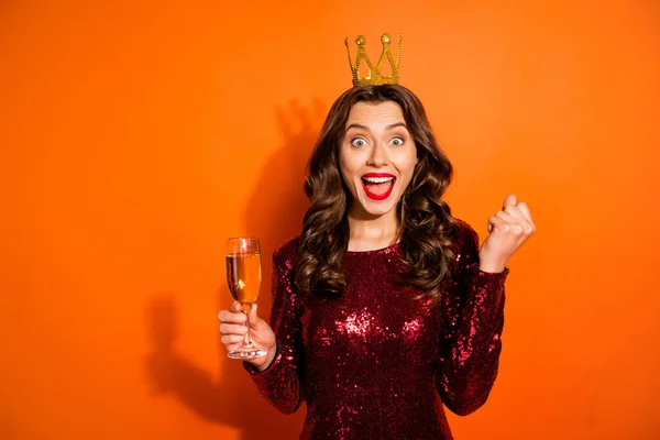 Retrato de chica soltera emocionada con corona en la cabeza celebrar champán escuchar noticias sobre su victoria en fiesta de graduación gritar wow omg usar vestido rojo borgoña aislado sobre fondo de color naranja — Foto de Stock