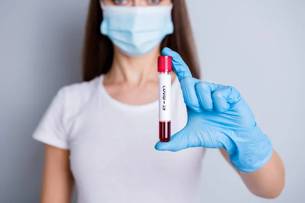 의사의 혈액 탐색기 성형 검사 마스크를 착용 한 의사의 얼굴을 분리 된 회색 배경으로 하여, 의사의 혈액 검사를 제공하는, 사람들 과 접촉하지 않는 여성 사회적 거리의 교차 사진 — 스톡 사진