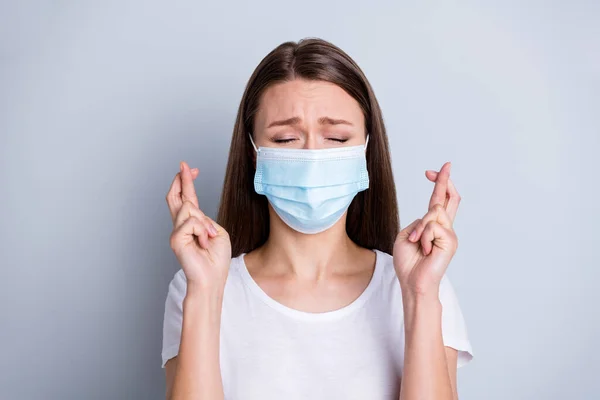 Foto de señora bonita tenía contacto infectados personas examen de hospital paciente aterrorizado ojos cerrados dedos cruzados rezando buenos resultados desgaste proteger la máscara facial aislado color gris fondo — Foto de Stock