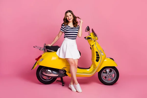 Portret van haar ze mooie aantrekkelijke mooie vrolijke vrolijke meisje zitten op bromfiets spelen met krullen huur service kopen krediet lening verkoop geïsoleerd op roze pastel kleur achtergrond — Stockfoto