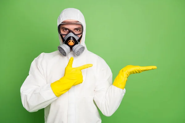 Retrato de trabajador médico mano mano mano dedo dedo copyspace indican covid19 prevención promoción anuncios desgaste látex hazmat uniforme aislado sobre fondo de color verde —  Fotos de Stock