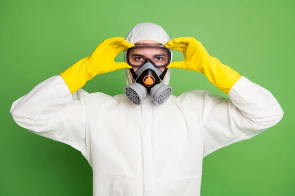 Retrato de cerca de su agradable contenido confiado desinfectante profesional poniendo equipo de máscara de gas en el servicio contra la enfermedad enfermedad enfermedad aislado sobre fondo de color pastel verde —  Fotos de Stock