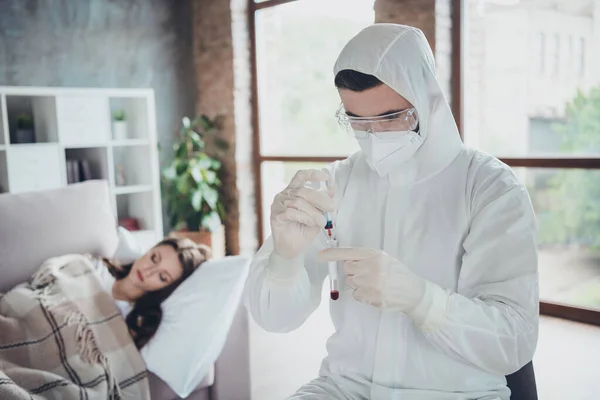 Photo of young sick patient lady lying unwell sofa cold under blanket call emergency flu cold covid symptom doc collected blood probe medical test wear latex gloves protective uniform indoors — Stock Photo, Image
