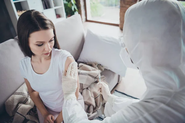 Foto de joven enferma paciente señora sentirse mal llamada ambulancia de emergencia doc quejándose gripe resfriado covid síntomas tomar antibiótico inyección hombro medicación usar guantes protección uniforme interior — Foto de Stock