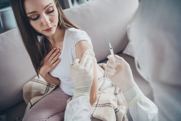 Foto de joven enferma enferma paciente señora se siente mal llamada ambulancia de emergencia doc virólogo gripe resfriado covid hacer antibiótico inyección hombro medicación usar guantes uniforme protector interior — Foto de Stock