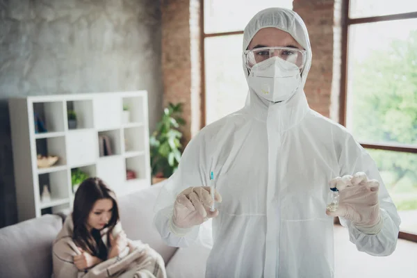 Foto de jovem doente senhora deitado sofá mal-estar chamar ambulância de emergência profissional gripe frio covid procedimento de imunização por injeção usar máscara luvas de látex uniforme de proteção dentro de casa — Fotografia de Stock