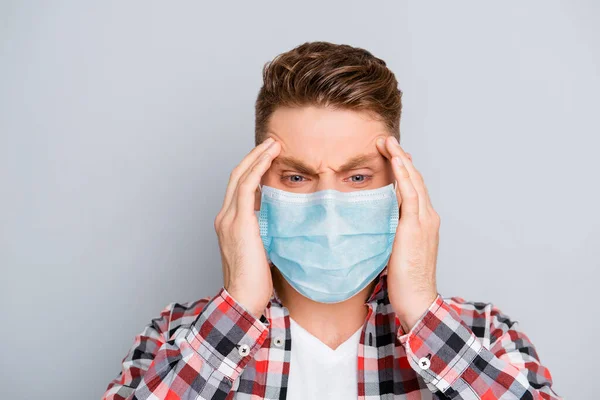 Portret van zieke jonge man in shirt dragen medische veiligheid gezichtsmasker, aanraken van zijn hoofd voelen pijn influenza respiratoire ziekte symptoom temperatuur koud, corona virus pandemie 2020 concept — Stockfoto