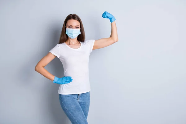 Photo of cool lady raise fist demonstrate strong immune system sport save world not afraid corona virus covid wear latex gloves protect face mask isolated grey color background