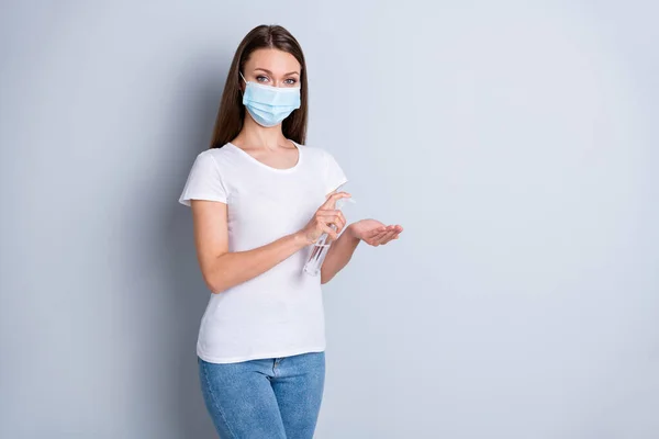 Foto de bela senhora distância social evitar pessoas contato segurar anti-séptico grande garrafa sabão desinfecção conceito de segurança desgaste proteger máscara facial camiseta jeans isolado cor cinza fundo — Fotografia de Stock