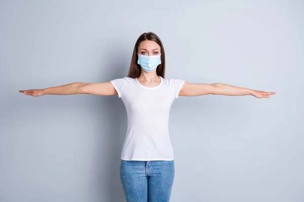 Photo of serious lady keep social distance avoid afraid of people contact raise arms both sides empty space stand two meter block movement wear protect mask isolated grey color background — Stockfoto