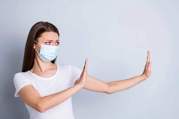 Photo of serious lady keep social distance avoid afraid of people contact raise arms side empty space stay away from me concept wear protect face mask isolated grey color background — Stockfoto