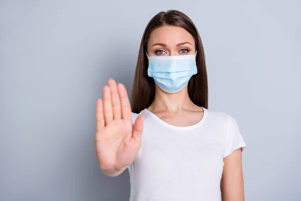 Photo of pretty serious lady keep social distance avoid people contacting hospital examination raise arm stand far away wear protect face mask t-shirt isolated grey color background — Stockfoto