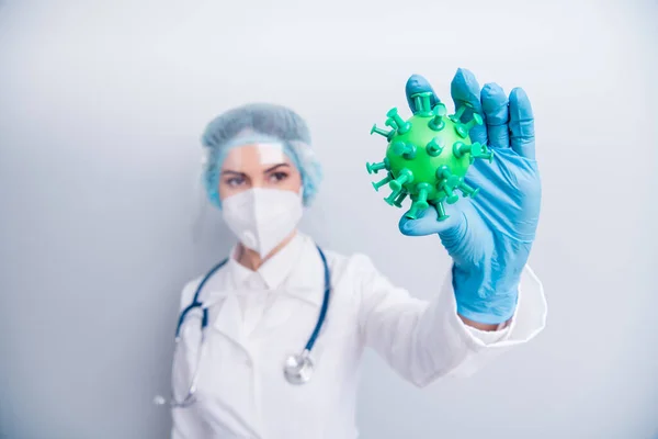 Close up photo of lady doc hold covid bacteria simulation analysing infegious process vaccine research wear gloves mask coat facial plastic surgical cap isolated grey color background — Zdjęcie stockowe