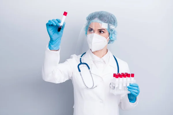 Φωτογραφία από τον γιατρό ιολόγο έμπειρο νοσηλευτή κρατήστε το αίμα καθετήρα covid ασθενή εργαστηριακή δοκιμή φθορά παλτό μάσκα προσώπου πλαστική ασπίδα προστασίας χειρουργικό κάλυμμα απομονωμένο γκρι φόντο — Φωτογραφία Αρχείου