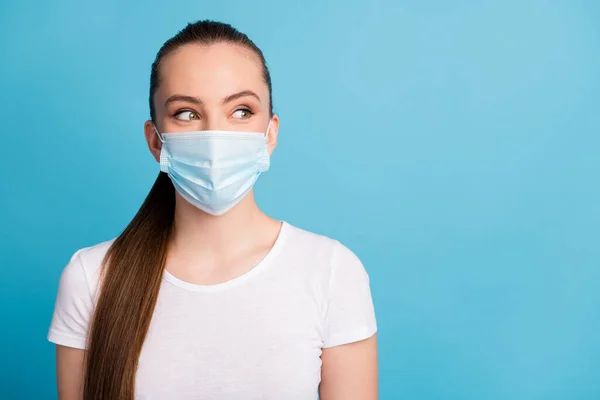 Close-up foto van mooie jonge dame kijken kant lege ruimte houden sociale afstand niet in contact met mensen grappige uitdrukking dragen beschermen gezicht medisch masker wit t-shirt geïsoleerde blauwe kleur achtergrond — Stockfoto