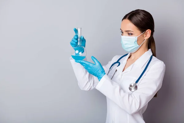 Foto de virologista serio doc lady experimentado profesional mantenga el tubo de ensayo de vidrio examinando la vacuna use guantes mascarilla facial uniforme bata de laboratorio estetoscopio aislado fondo gris — Foto de Stock