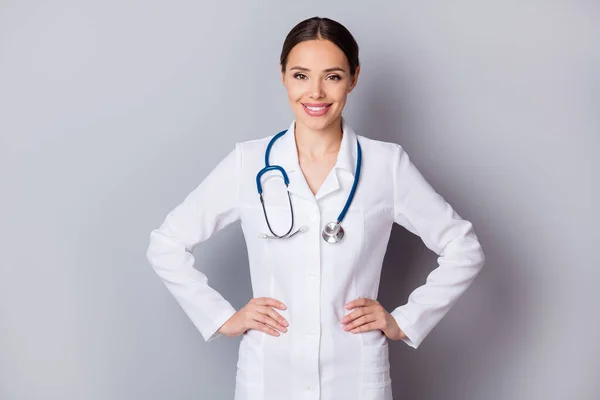 Foto von attraktiven fröhlichen Hausarzt doc zahn lächelnd erfahrene professionelle Arme von Seiten tragen medizinische Uniform Labormantel Stethoskop isoliert grauen Hintergrund — Stockfoto