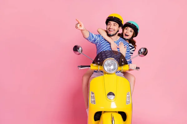 Retrato de sua ele ela agradável atraente agradável alegre alegre feliz casal surpreso equitação ciclomotor se divertindo apontando indicador espaço cópia anúncio isolado no fundo cor pastel rosa — Fotografia de Stock