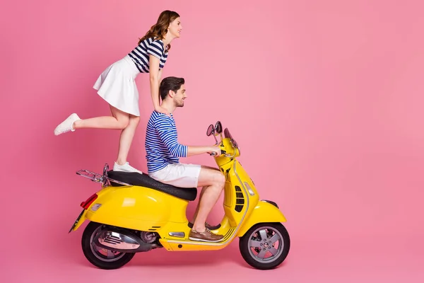 Profiel zijaanzicht portret van zijn hij haar zij mooi aantrekkelijk vrolijk vrolijk funky zorgeloos paar rijden bromfiets meisje staande fooling hebben leuk weekend geïsoleerd op roze pastel kleur achtergrond — Stockfoto